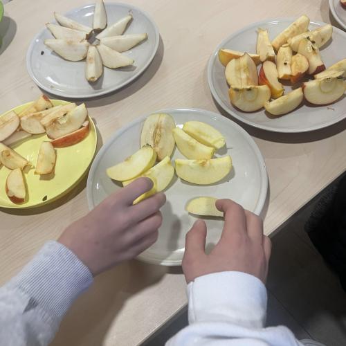 Kinderhänden langen nach Apfelstücken