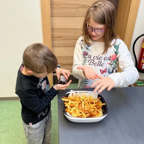 Kinder bei der Zubereitung von Pommes