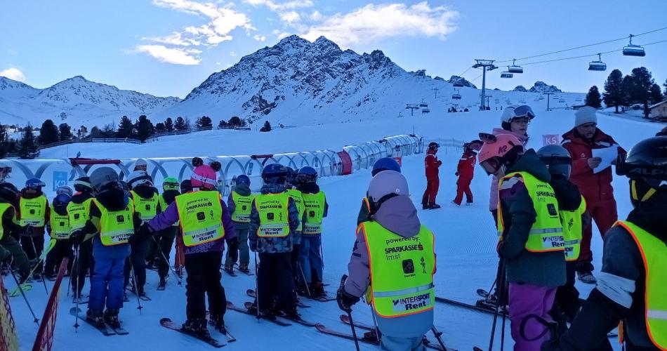 Kinder beim Skifahren mit gelber Weste